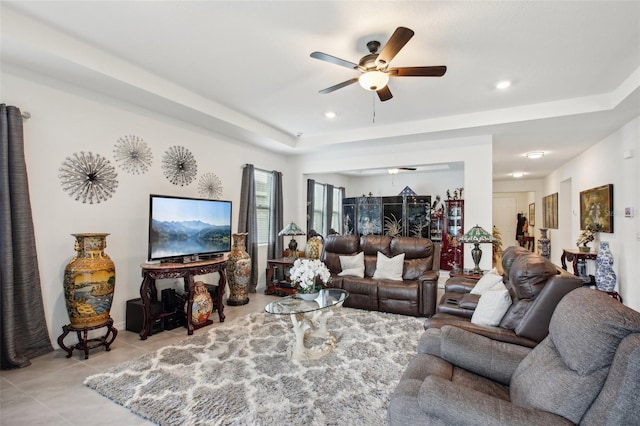 living room with light tile patterned floors, a tray ceiling, recessed lighting, and ceiling fan
