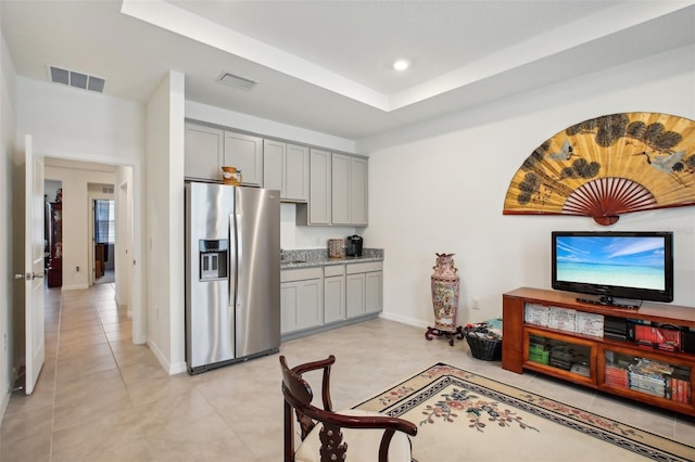 kitchen with light tile patterned flooring, gray cabinets, stainless steel fridge with ice dispenser, baseboards, and visible vents