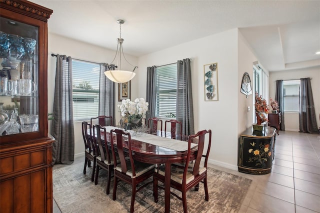 tiled dining area featuring plenty of natural light and baseboards