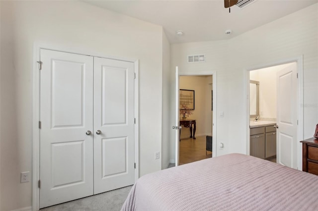 carpeted bedroom with a closet, visible vents, baseboards, and connected bathroom