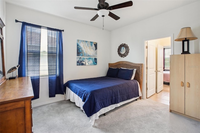 bedroom with a ceiling fan, baseboards, and light carpet