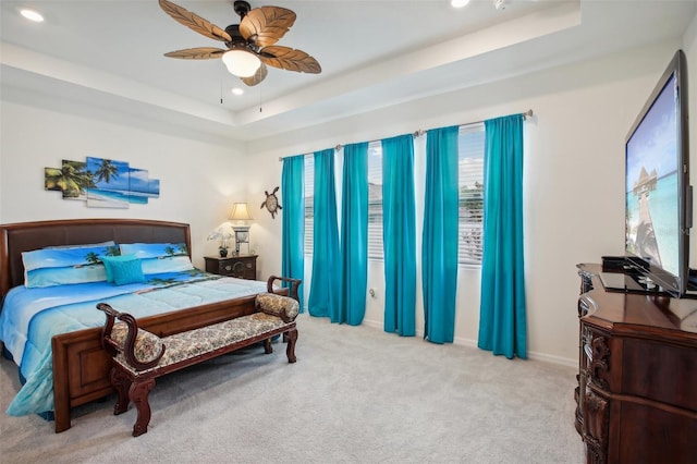 carpeted bedroom featuring a tray ceiling, baseboards, ceiling fan, and recessed lighting