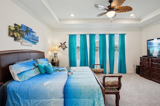carpeted bedroom with a tray ceiling, a ceiling fan, and recessed lighting