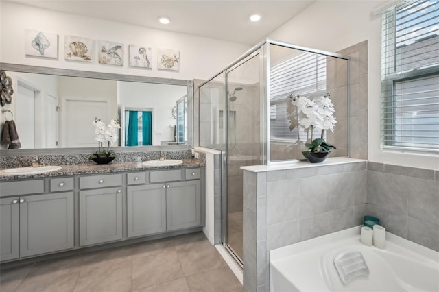 full bath featuring a shower stall, a wealth of natural light, tile patterned floors, and a sink