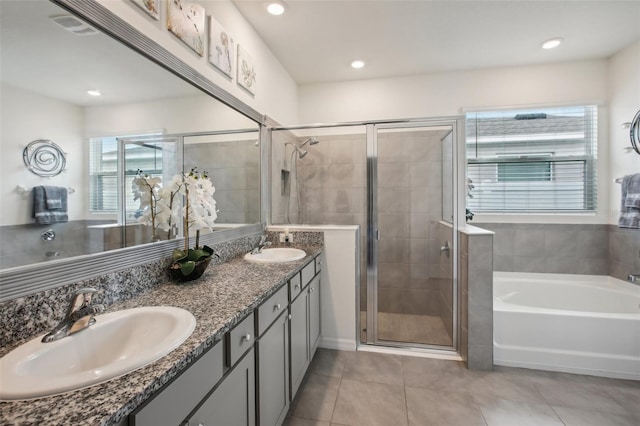 bathroom featuring a shower stall, a sink, a bath, double vanity, and tile patterned flooring