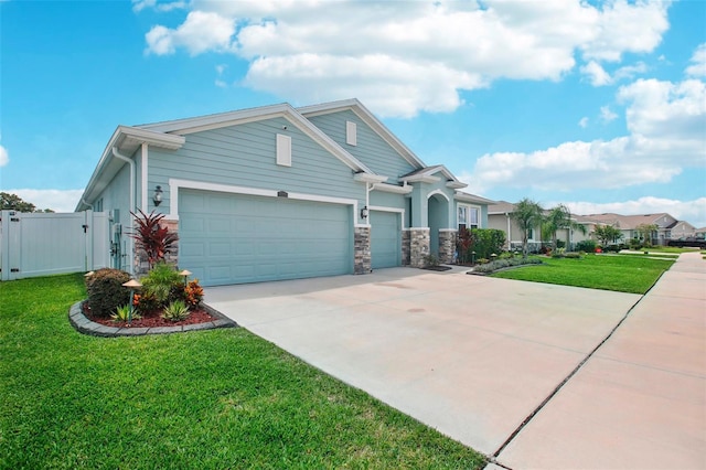 7323 Steer Blade Dr, Zephyrhills, FL 33541 - view of front of house with driveway, an attached garage, a gate, and stone siding