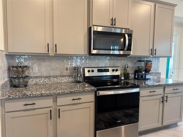 7323 Steer Blade Dr, Zephyrhills, FL 33541 - kitchen featuring appliances with stainless steel finishes, stone countertops, decorative backsplash, and light tile patterned floors