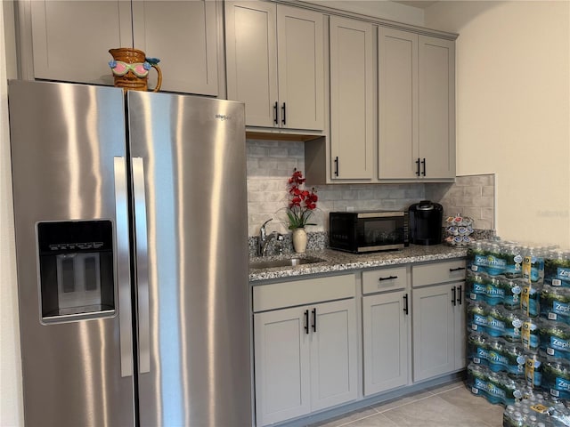 7323 Steer Blade Dr, Zephyrhills, FL 33541 - kitchen featuring stainless steel fridge, black microwave, gray cabinets, a sink, and backsplash
