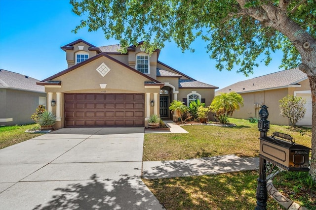 view of front of house featuring stucco siding, driveway, a front yard, and a garage