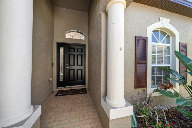 doorway to property featuring stucco siding