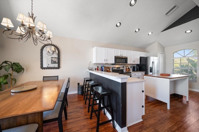 kitchen with white cabinets, lofted ceiling, visible vents, appliances with stainless steel finishes, and dark wood-style flooring
