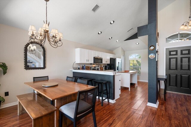 dining area featuring lofted ceiling, dark wood-style floors, visible vents, and a chandelier