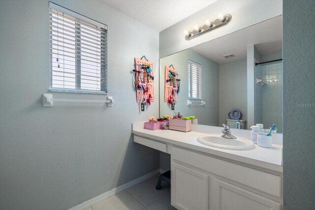 full bathroom featuring tile patterned flooring, visible vents, vanity, baseboards, and a shower