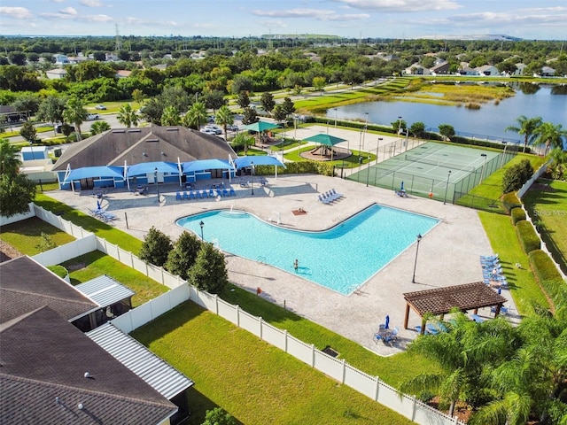 pool with a lawn, fence, a water view, and a patio