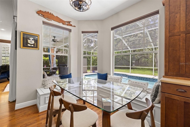5902 Audubon Manor Blvd, Lithia, FL 33547 - dining area with wood finished floors, baseboards, a chandelier, a sunroom, and ceiling fan