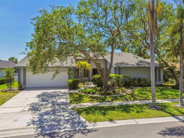 4226 Saltwater Blvd, Tampa, FL 33615 - view of front of house featuring concrete driveway, roof with shingles, an attached garage, and a front yard