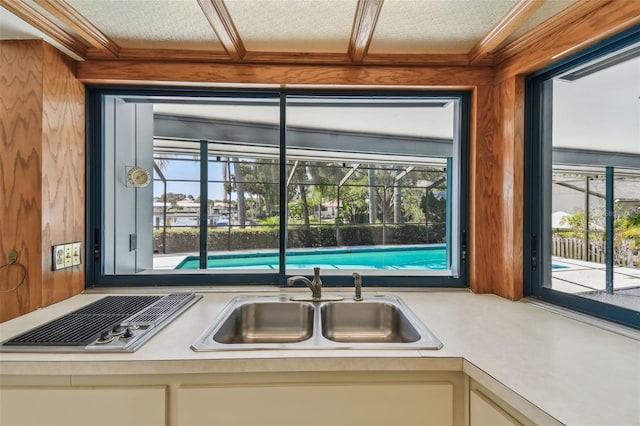 4226 Saltwater Blvd, Tampa, FL 33615 - kitchen with ornamental molding, stainless steel stovetop, light countertops, white cabinets, and a sink