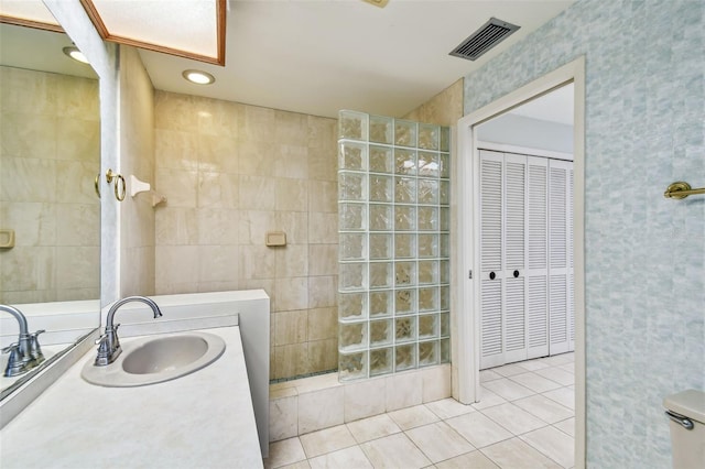 4226 Saltwater Blvd, Tampa, FL 33615 - full bath featuring visible vents, tile walls, a walk in shower, tile patterned floors, and vanity