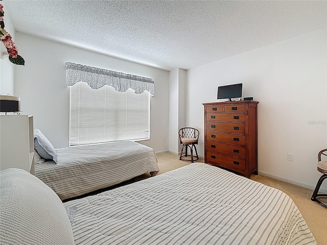 bedroom with a textured ceiling and light carpet