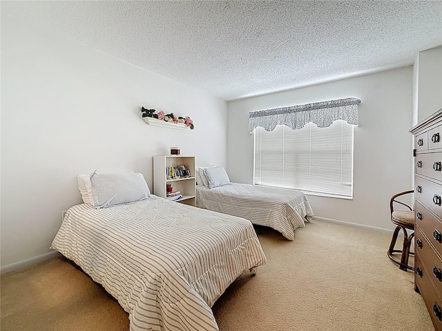 carpeted bedroom featuring a textured ceiling and baseboards