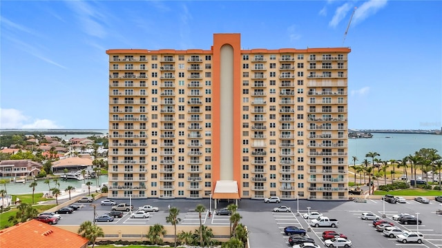 view of building exterior with a water view and uncovered parking