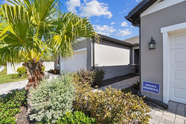 view of property exterior with a garage and stucco siding