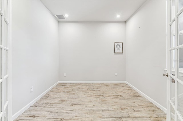empty room with recessed lighting, wood finished floors, baseboards, visible vents, and french doors
