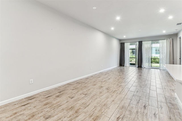 empty room with visible vents, light wood-type flooring, recessed lighting, and baseboards