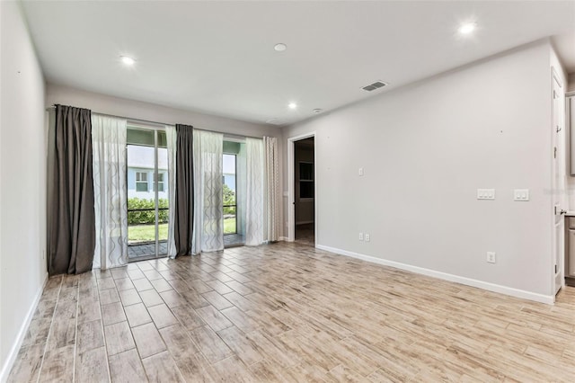 empty room featuring visible vents, recessed lighting, light wood-style flooring, and baseboards