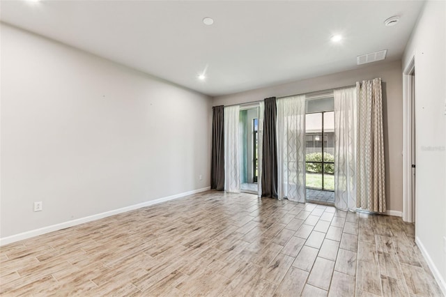 spare room featuring baseboards, visible vents, light wood-style floors, and recessed lighting