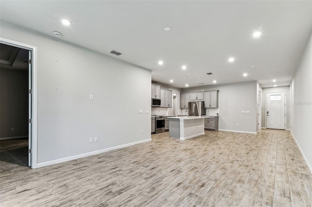 unfurnished living room featuring visible vents, recessed lighting, baseboards, and light wood-style floors