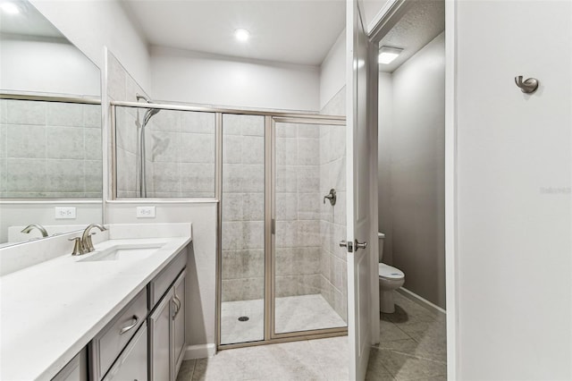 full bath with tile patterned flooring, a shower stall, toilet, vanity, and baseboards