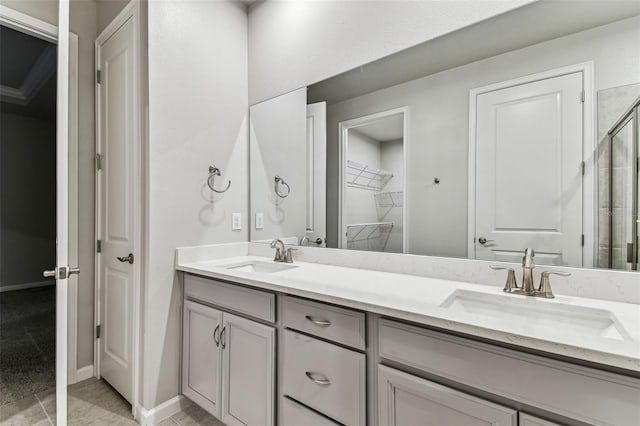 full bathroom with a walk in closet, a shower with shower door, double vanity, and a sink