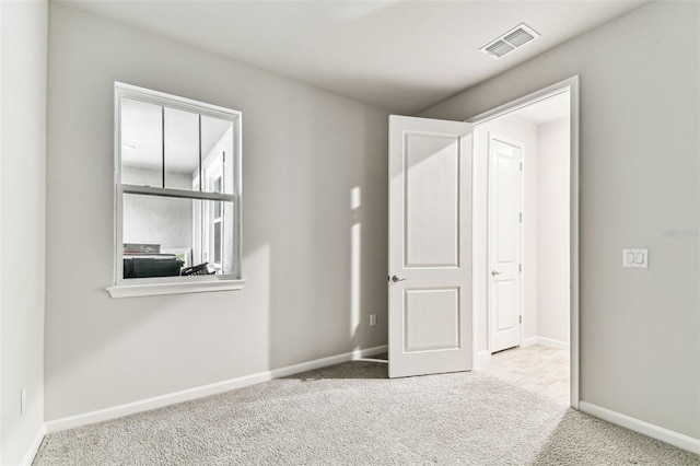 unfurnished bedroom with carpet flooring, visible vents, and baseboards