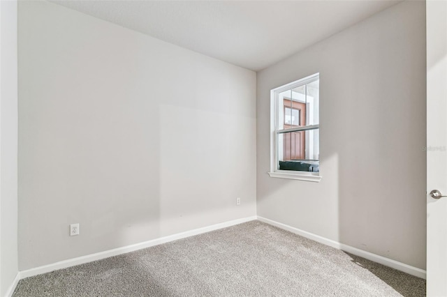 spare room featuring carpet and baseboards