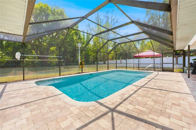 view of swimming pool with a fenced backyard, a patio, a fenced in pool, and glass enclosure