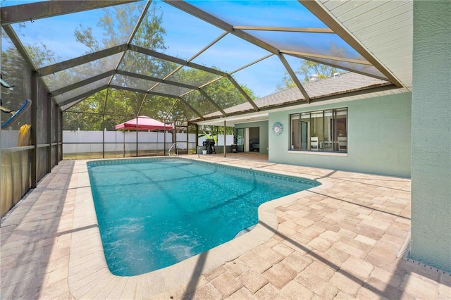 view of pool featuring a fenced backyard, a patio area, a fenced in pool, and glass enclosure