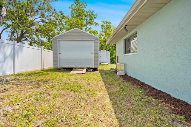 view of yard with fence, an outbuilding, and a storage shed