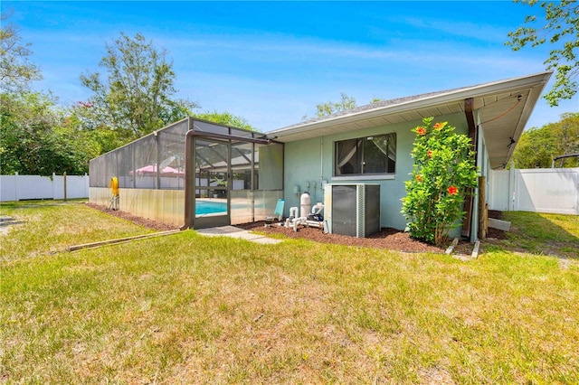 rear view of property with a yard, a fenced in pool, a fenced backyard, and central AC unit
