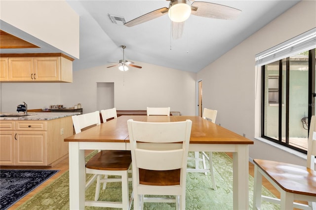 dining space featuring vaulted ceiling, visible vents, ceiling fan, and a healthy amount of sunlight