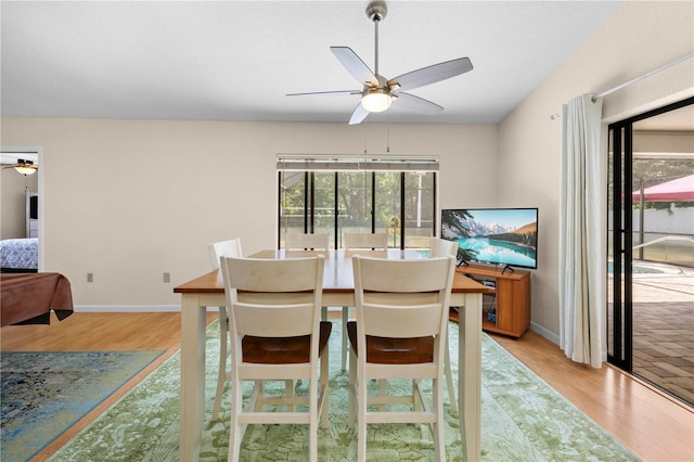 dining room featuring a ceiling fan, baseboards, and light wood-style floors