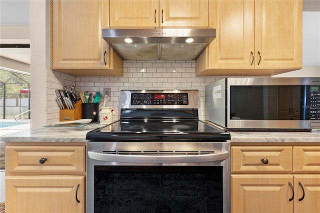 kitchen featuring under cabinet range hood, decorative backsplash, appliances with stainless steel finishes, and light brown cabinetry