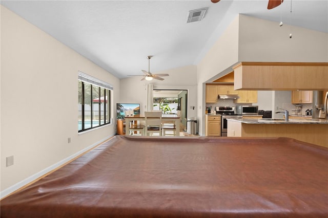interior space with baseboards, vaulted ceiling, visible vents, and ceiling fan