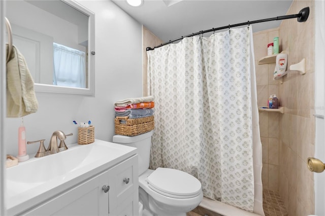 bathroom with a tile shower, toilet, and vanity