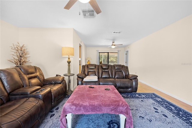 living room featuring baseboards, a ceiling fan, and visible vents