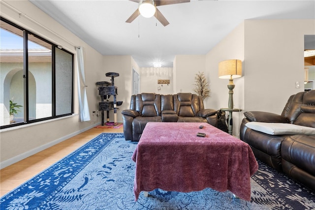 living room with plenty of natural light, a ceiling fan, wood finished floors, and baseboards