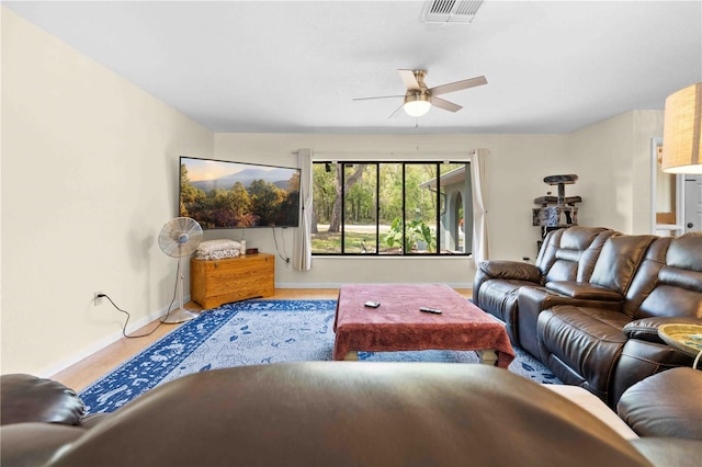 living area with visible vents, baseboards, and ceiling fan