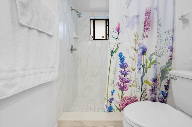 bathroom featuring tiled shower and toilet