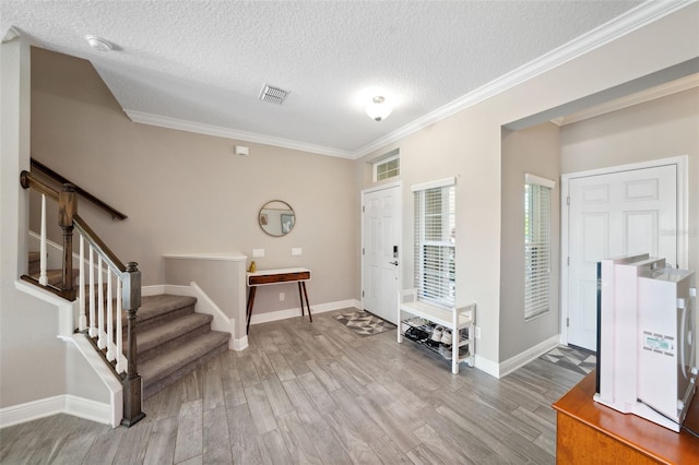 entryway with baseboards, ornamental molding, and wood finished floors