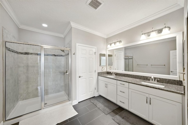 bathroom featuring a sink, ornamental molding, a shower stall, and visible vents